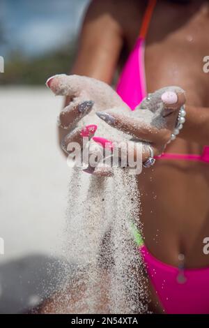 Poncer les doigts de la main d'une femme portant un bikini rose Banque D'Images