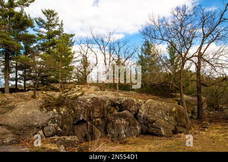 Le basalte des coulées de lave antiques constitue la roche du parc national Interstate avec des arbres contre un ciel bleu nuageux à Taylors Falls, Minnesota, États-Unis. Banque D'Images