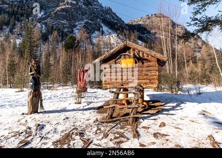 Une ancienne hutte russe sur des cuisses de poulet et une statue de Baba Yaga. Célèbre personnage d'un conte de fées pour enfants. République de l'Altaï, Russie. 19 novembre 2020 Banque D'Images