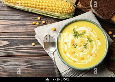 Délicieuse soupe crémeuse de maïs servie sur une table en bois, sur une table plate Banque D'Images