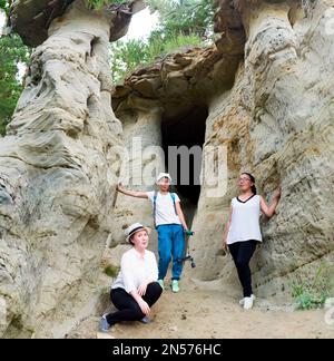 Trois filles copines touristes avec caméra en t-shirts blancs sont la valeur des attractions Yakutia les champignons de sable et les grottes errozitsionnykh formes Terra Banque D'Images