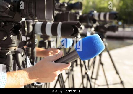 Journalistes avec microphones et caméras vidéo à l'extérieur, gros plan Banque D'Images