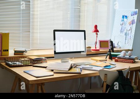Lieu de travail avec moniteur d'ordinateur sur la table pour l'étude en ligne dans la salle de l'adolescence Banque D'Images