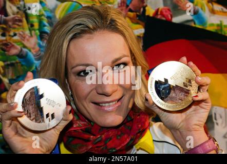 FILE - In this Feb. 15, 2014 file picture Germany's Maria Hoefl-Riesch poses with her gold and silver medal at the German house at the 2014 Winter Olympics in Krasnaya Polyana, Russia. Three-time Olympic champion Maria Hoefl-Riesch of Germany is retiring from Alpine skiing. Hoefl-Riesch told reporters in Munich on Thursday March 20, 2014 that her decision was 'to end my career now.' The 29-year-old German was the 2011 overall World Cup winner. (AP Photo/Gero Breloer,File)
