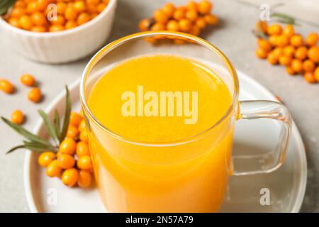 Délicieux thé d'argousier dans une tasse de verre sur la table, en gros plan Banque D'Images