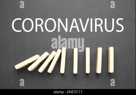 Chute de tuiles domino et du mot coronavirus sur fond gris, plat. Diffusion du concept covid19 Banque D'Images