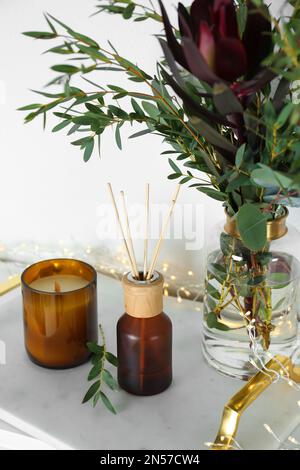 Désodorisant Reed avec bougie et bouquet sur plateau en marbre Banque D'Images