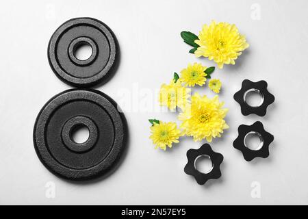 8 mars carte de voeux avec fleurs de chrysanthème et plaques de poids sur fond gris clair, plat. Journée internationale de la femme Banque D'Images