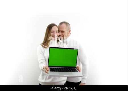 homme et femme sur fond blanc dans les mains avec ordinateur portable avec écran vert chromakey fille est très heureux satisfait annonce produit en ligne formation homme chuchots quelque chose dans l'oreille achats en ligne Banque D'Images