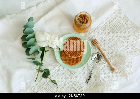 gaufres et miel avec fleur de pivoine sur la table, vue du dessus Banque D'Images