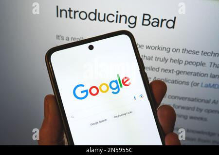 Google lance Bard ai. Barre de recherche Google sur un téléphone en main avec les informations de libération en arrière-plan. Google Bard ai contre OpenAI ChatGPT. Varsovie, Pologne - 8 février 2023. Banque D'Images