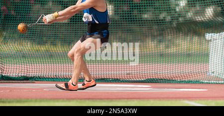 Un athlète participant à l'épreuve de jet de marteau, un athlète exécutant un jet de marteau dans le stade Banque D'Images
