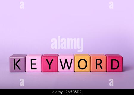 Cubes colorés avec mot-CLÉ sur fond lilas Banque D'Images
