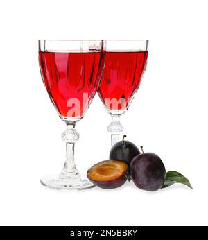 Délicieux liqueurs de prunes et fruits mûrs sur fond blanc. Boisson alcoolisée maison forte Banque D'Images