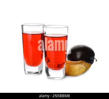 Délicieux liqueurs de prunes et fruits mûrs sur fond blanc. Boisson alcoolisée maison forte Banque D'Images