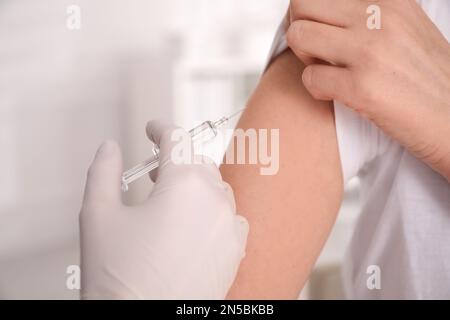 Médecin vaccinant la femme contre Covid-19 en clinique, en gros plan Banque D'Images