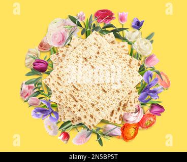 Savoureux matzos et fleurs sur fond jaune, plat. Fête de la Pâque (Pesach) Banque D'Images