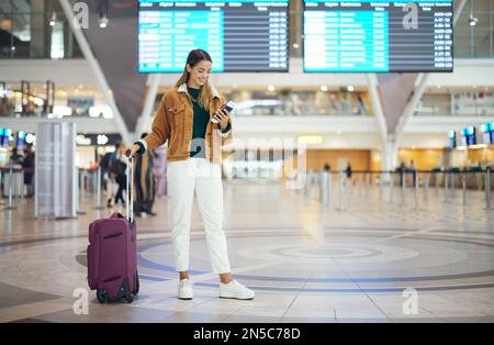 Voyage, femme à l'aéroport et bagages pour les vacances, pause et fille excitée, sourire et vérifier le billet d'embarquement. Femme, femme et voyageur avec valise Banque D'Images