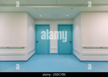 Couloir de l'hôpital avec portes et planchers bleus Banque D'Images