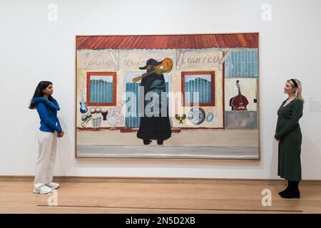 LONDRES, ROYAUME-UNI - 09 FÉVRIER 2023 : les membres du personnel de la galerie regardent un tableau intitulé 'Music Shop' (2019-23) par Peter Doig (né en 1959), lors d'une séance photo pour la grande exposition des œuvres récentes et nouvelles de Peter Doig à la Courtauld Gallery de Londres, Royaume-Uni sur 09 février 2023. Exposition Morgan Stanley : Peter Doig (10 février - 29 mai 2023) présentera un nouveau chapitre passionnant dans la carrière de l'un des peintres les plus célèbres et les plus importants travaillant aujourd'hui et la première exposition d'un artiste contemporain à avoir lieu à la Courtauld depuis sa réouverture en novembre 2021 f Banque D'Images