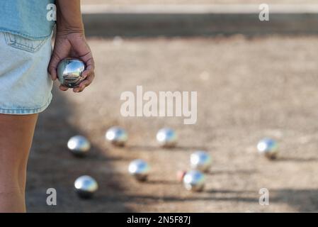 Senior jouant à la pétanque un et jeu relaxant, balles sur le terrain. Femme âgée prête à jeter la boule dans un parc en plein air Banque D'Images