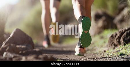 Jeune couple en bonne santé qui court sur un sentier de montagne le matin. Trail course marathon fitness pieds sur le rock fitness et un mode de vie sain Banque D'Images