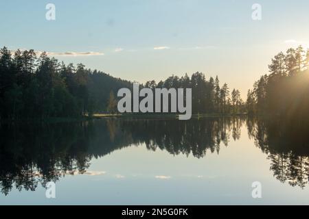 Lac forestier en Suède l'été en fin d'après-midi, après le coucher du soleil. Lac de Nydala à Umea sous un ciel bleu-rose apaisant. Image de nature relaxante. Découvrez SCA Banque D'Images