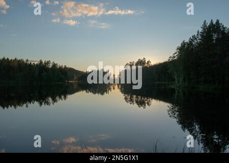 Lac forestier en Suède l'été en fin d'après-midi, après le coucher du soleil. Lac de Nydala à Umea sous un ciel bleu-rose apaisant. Image de nature relaxante. Découvrez SCA Banque D'Images