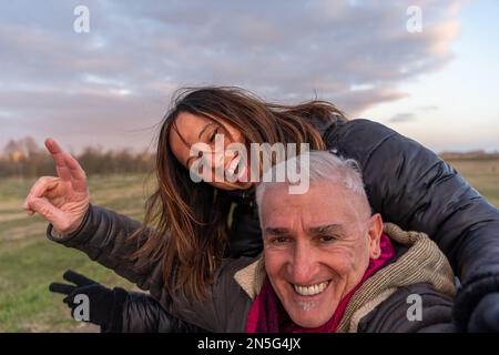 couple d'âge moyen portant des vêtements d'hiver prenant un selfie à la campagne - concept de personnes en loisirs Banque D'Images