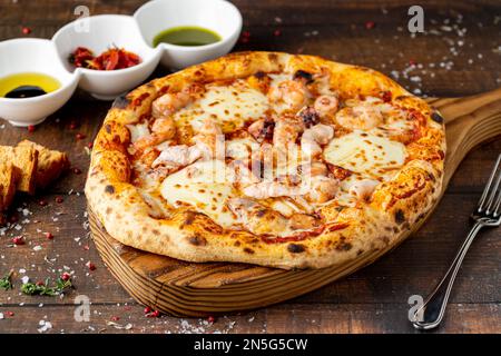 Pizza italienne avec crevettes et mozzarella sur un plan de coupe Banque D'Images