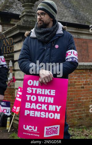 Egham, Royaume-Uni. 9th février 2023. Un membre du personnel universitaire de l'UCU (University and College Union) tient une pancarte à un piquet officiel devant l'Université Royal Holloway de Londres le premier jour de l'action de grève. Plus de 70 000 employés dans 150 universités du Royaume-Uni devraient prendre part à la grève de deux jours en cours sur les salaires et les conditions telles que les pratiques de travail et les charges de travail peu sûres, après que 80 % des membres aient voté pour rejeter la dernière offre de salaire des employeurs. Crédit : Mark Kerrison/Alamy Live News Banque D'Images