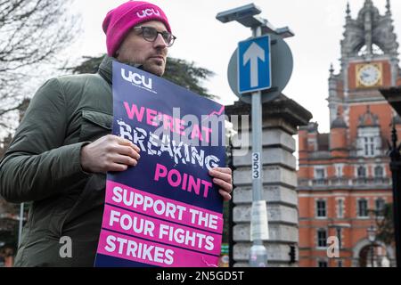 Egham, Royaume-Uni. 9th février 2023. Un membre du personnel universitaire de l'UCU (University and College Union) tient une pancarte à un piquet officiel devant l'Université Royal Holloway de Londres le premier jour de l'action de grève. Plus de 70 000 employés dans 150 universités du Royaume-Uni devraient prendre part à la grève de deux jours en cours sur les salaires et les conditions telles que les pratiques de travail et les charges de travail peu sûres, après que 80 % des membres aient voté pour rejeter la dernière offre de salaire des employeurs. Crédit : Mark Kerrison/Alamy Live News Banque D'Images