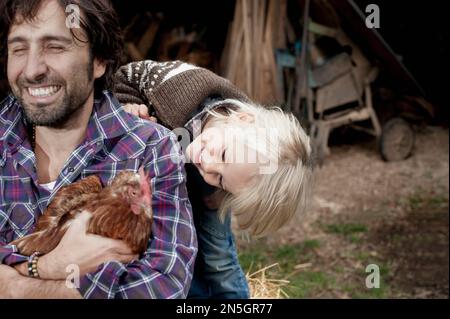 Père et fils jouant dans la ferme, Bavière, Allemagne Banque D'Images