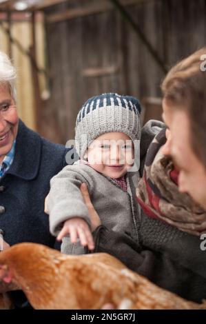 Mère tenant son bébé fils dans ses bras dans la ferme, Bavière, Allemagne Banque D'Images