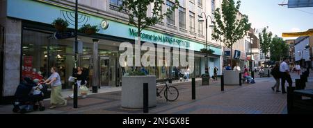 Sutton Town Center Surrey England People Shopping à High Street Marks and Spencer avec des bains à fleurs municipaux à l'extérieur Banque D'Images