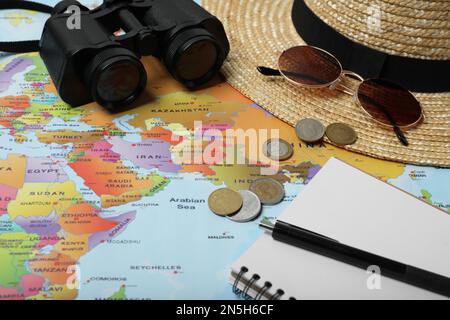 Différents accessoires de voyage sur la carte du monde. Planification de vacances d'été Banque D'Images