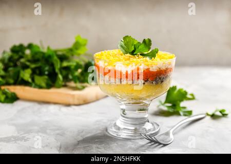 Salade russe traditionnelle Mimosa servie sur une table gris clair Banque D'Images