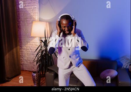 Homme noir décontracté dans le casque. Un homme écoute de la musique à la maison. Homme afro-américain appréciant la musique Banque D'Images