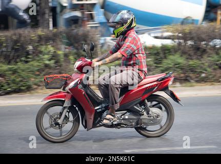 SAMUT PRAKAN, THAÏLANDE, FÉVRIER 04 2023, Un homme fait une moto dans la rue de la ville Banque D'Images