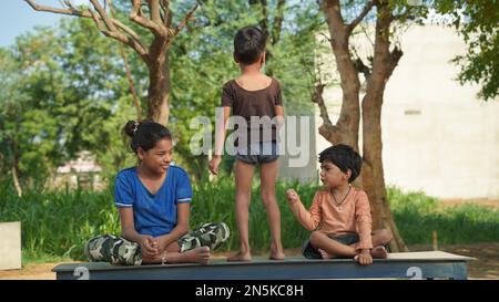 Les enfants qui font du yoga posent dans le parc à l'extérieur. Concept de style de vie sain. Banque D'Images