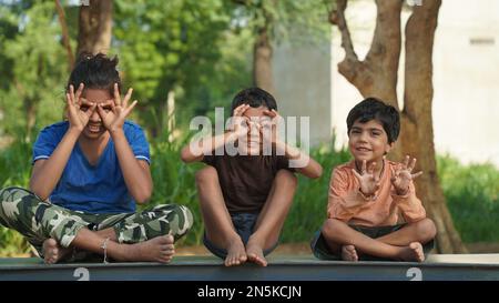 Les enfants qui font du yoga posent dans le parc à l'extérieur. Concept de style de vie sain. Banque D'Images