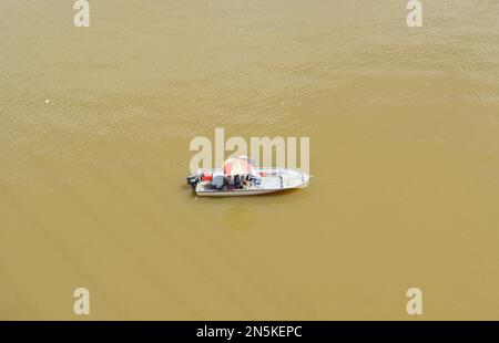 Pêcheur dans un bateau sur la rivière Kuching Sarawak Malaisie. Banque D'Images