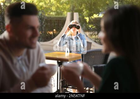 Jaloux ex petite amie espionnant un couple dans un café en plein air Banque D'Images