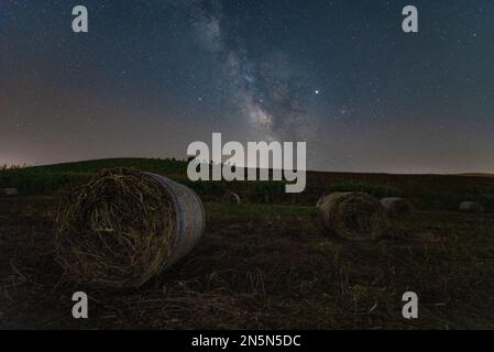 Vue nocturne avec la voie lactée d'un champ de balles de foin, Sicile Banque D'Images