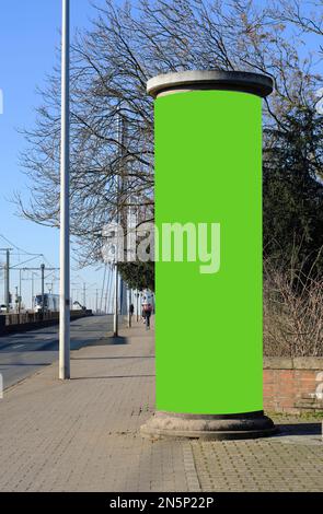 Vide publicité pilier sur une rue avec vert espace libre copie, maquette de promotion. Panneau publicitaire vierge avec des personnes non identifiables Banque D'Images