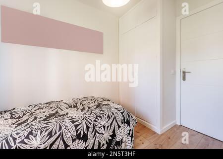 Chambre jeune avec lit simple, armoire intégrée avec portes en bois blanc et parquet en châtaignier Banque D'Images