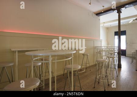 Tables hautes circulaires avec tabourets assortis dans un hall de restaurant Banque D'Images