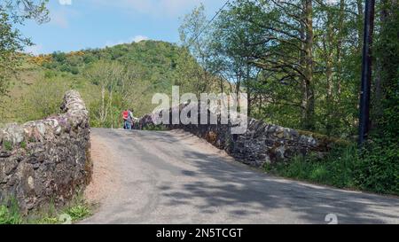 Marcheurs sur le pont de Gartchonzie, Rob Roy Way près de Callander, Trossachs, Écosse. Banque D'Images