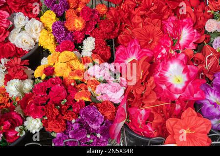 Fleurs artificielles colorées à l'extérieur du magasin Banque D'Images