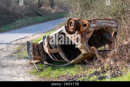 La voiture s'est retournée sur le côté de la route après avoir été brûlée en cas d'accident. Banque D'Images